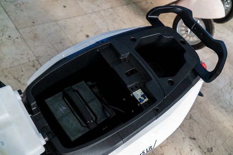 Open seat of a white Ofero Stareer 5 sample unit, showing a dark battery pack in the lower compartment